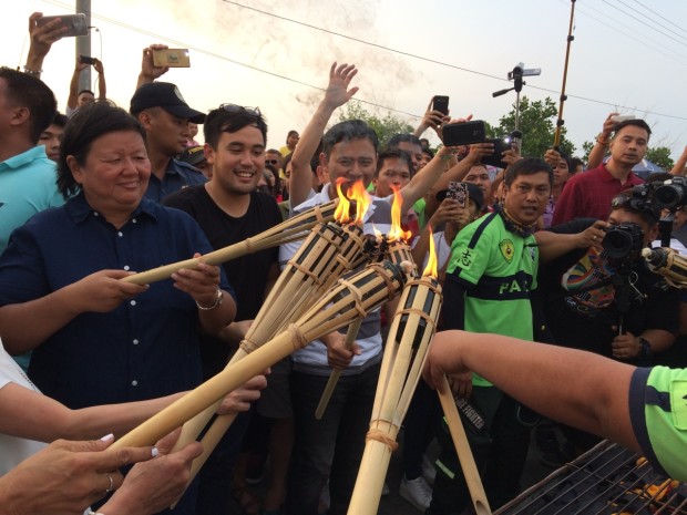 Dagupan City Mayor Belen Fernandez, Pangasinan Rep. Christopher de Venecia and Senator Sonny Angara (from left to right) lead the ceremonial lighting of 950 grills that would cook bangus (milkfish) along the De Venecia Highway on Sunday (April 30) for this year's Bangusan street party. The party is part of the 2017 Bangus Festival. Photo by Yolanda Sotelo INQ 