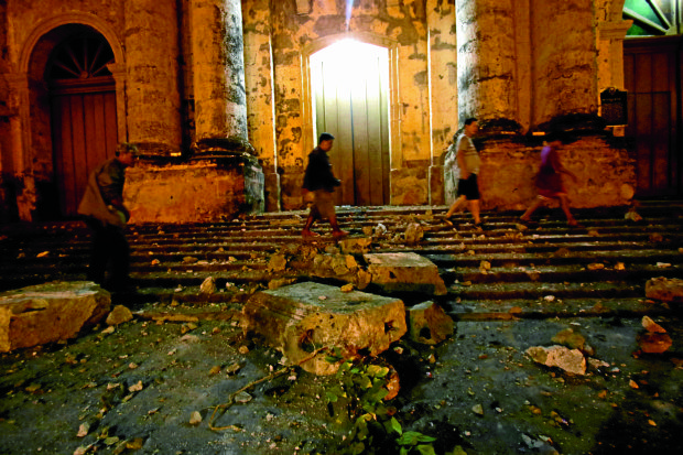 SLABSOFHISTORY Peoplewalk past debris from the historic Basilica of Saint Martin of Tours after an earthquake shook Taal town and the rest of Batangas province on Tuesday night, sending thousands of residents out of their homes and patients out of hospitals for safety. —RICHARDA. REYES