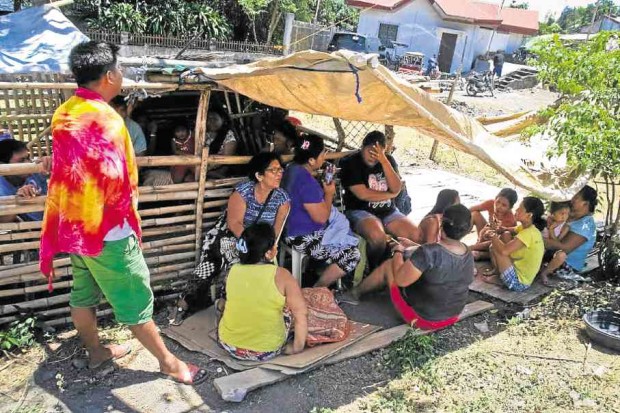 Residents afraid to stay indoors gather at a shed on a clearing in the village of Bagalangit in Mabini, Batangas, a day after the quake struck. —CHRIS QUINTANA/CONTRIBUTOR