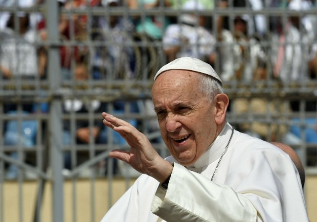 Pope Francis waves to worshippers before the start of a mass on April 29, 2017 at a stadium in Cairo.  Pope Francis is set to lead a mass for Egypt's small Catholic community as he visits the country in support of its Christians following a series of deadly church bombings. The spiritual leader of the world's almost 1.3 billion Catholics will lead mass for some 30,000 believers in a stadium on the outskirts of Cairo. AFP PHOTO
