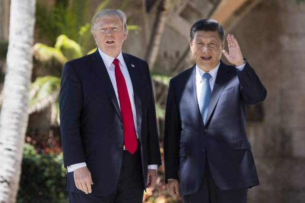 Chinese President Xi Jinping (R) waves to the press as he walks with US President Donald Trump at the Mar-a-Lago estate in West Palm Beach, Florida, April 7, 2017.  AFP