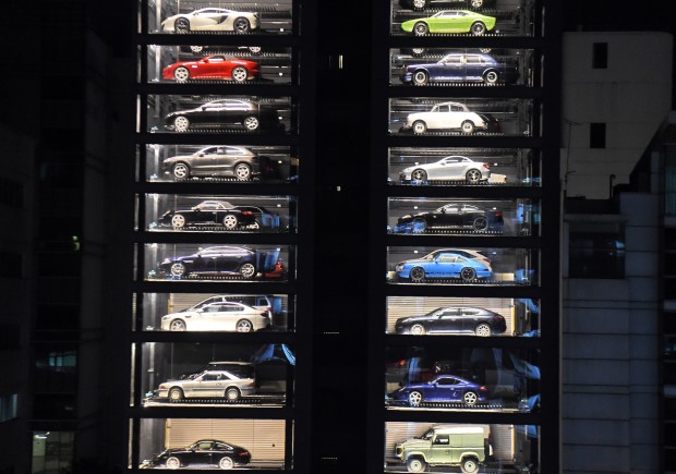Luxury supercars are displayed inside the AutoBahn Motors (ABM) building in Singapore on May 18, 2017. The building, which resembles an automobile 'vending machine' houses 60 of the million-dollar supercars owned by ABM owners Gary and Jack Hong, who invented the Automotive Inventory Management System (AIMS). / AFP PHOTO / ROSLAN RAHMAN