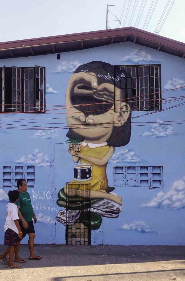 COLOR SPLASHA two-floor structure in the village of Panapaan 7 in Bacoor City in Cavite gets a splash of color through a surrealist image of a girl painted by muralist “BLIC.”  —PHOTO COURTESY OF CAVITE ACTIVE PHOTOGROUP