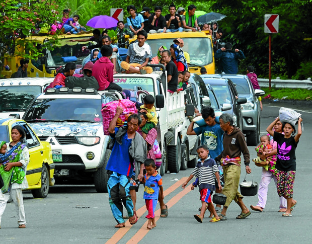 Beleaguered residents, including women and children, bring whatever they can as they flee Marawi City to escape the fighting between government troops and terrorists who have occupied portions of the city. —AFP
