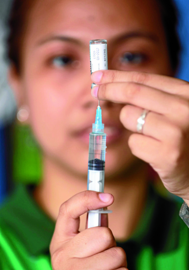 A nurse prepares a dengue vaccine for public school kids. —NIÑO JESUS ORBETA