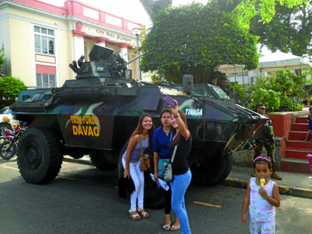 Just another ordinary day. Locals pause for selfie shots at an armored personnel carrier manned by the Task Force Davao and positioned right outside the City Hall. Photo by Joselle R. Badilla 