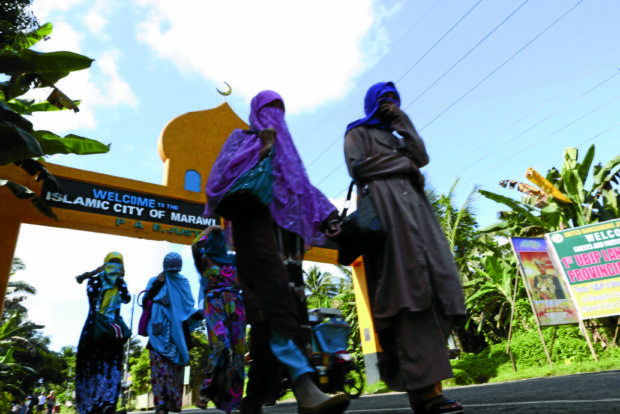 MOVING OUT Residents in the predominantly Muslim city of Marawi leave as fighting intensifies between themilitary and terrorists. —JEOFFREY MAITEM