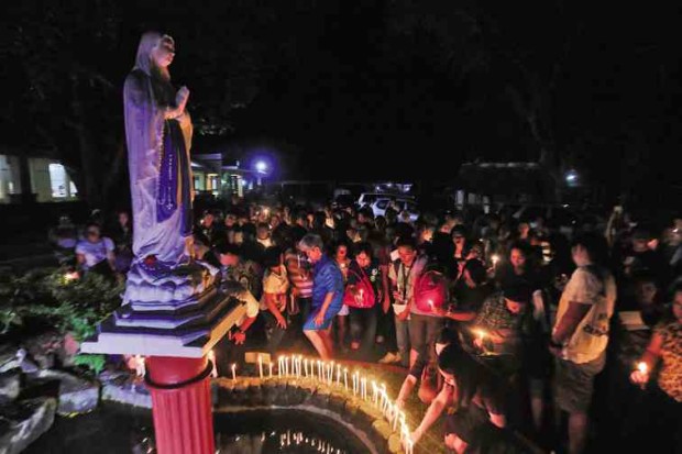 PRAYING FOR PEACE Residents of Albay province join a candle-lighting ceremony at Redemptorist Church in Legazpi City to pray for peace amid the fighting in Marawi City and the declaration of martial law in Mindanao. —MARK ALVIC ESPLANA