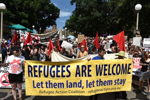 Protestors march on the streets of Sydney's central business district against US President Donald Trump's travel ban policy on February 4, 2017.  A large number of people from different walks of life holding banners and placards marched to the US consulate protesting against Trump's travel ban policy and demanded Australian government to settle all the refugees and asylum seekers in the county. / AFP PHOTO / SAEED KHAN
