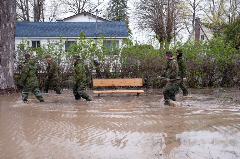 The Canadian army patrol the streets of Pierrefonds to help the residents after heavy flooding caused by unrelenting rain in Central and Eastern Canada on May 7,2017. More than 130 communities in the province have been hit by the flooding, with an estimated 1,500 homes affected and 850 people forced to evacuate. / AFP PHOTO / Catherine Legault
