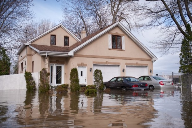 Homes in the Montreal borough of Pierrefonds are flooded on May 8, 2017.  With heavy rains persisting and waters still rising over much of waterlogged eastern Canada, the nation's military tripled the number of troops urgently working to evacuate thousands of residents. Montreal Mayor Denis Coderre declared a state of emergency for his city, allowing authorities to order mandatory evacuations from threatened areas. / AFP PHOTO / Catherine Legault