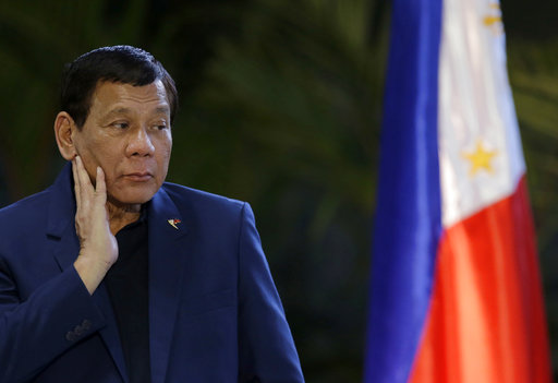 Philippine President Rodrigo Duterte listens to questions from reporters as he arrives at Manila's international airport, Philippines, Wednesday, May 24, 2017. Duterte warned Wednesday that he'll be harsh in enforcing martial law in his country's south as he abruptly left Moscow to deal with a crisis at home sparked by a Muslim extremist siege on a city, where militants burned buildings overnight and are feared to have taken hostages. (AP Photo/Aaron Favila)