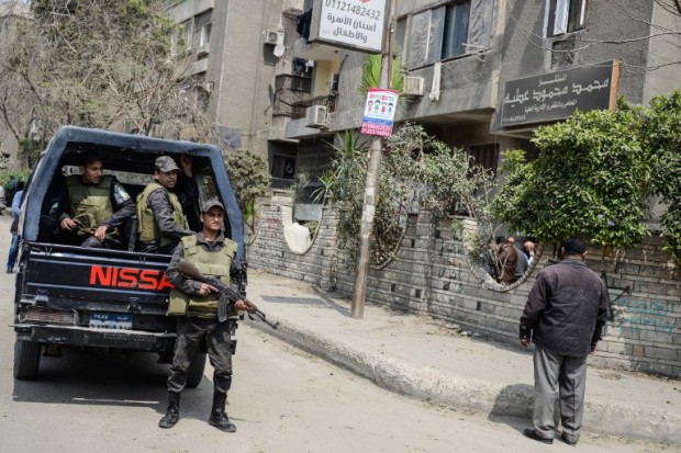 Policemen stand guard outside a building where an explosion took place in the southern suburb of Maadi in the Egyptian capital Cairo on March 24, 217. According to a statement by the interior ministry, the blast which was caused by a "strange metal device" killed a 35-year-old doorman as he cleaned a garden, in addition to injuring his wife and two sons. Islamist militants have set off bombs in Cairo, usually targeting policemen, since the 2013 overthrow of president Mohamed Morsi, a Muslim Brotherhood politician. / AFP PHOTO / MOHAMED EL-SHAHED