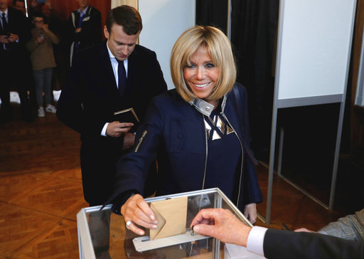 Brigitte Macron, wife of French presidential election candidate for the En Marche ! movement Emmanuel Macron, casts her ballot while Emmanuel Macron looks on at a polling station in Le Touquet, northern France, during the second round of the French presidential election, Sunday, May 7, 2017. (Philippe Wojazer/Pool Photo via AP)