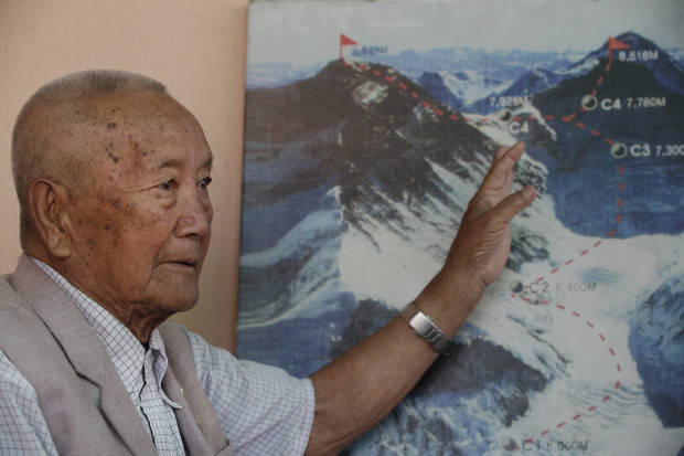 In this Tuesday, April 11, 2017 photo, Nepalese climber Min Bahadur Sherchan, points to a picture to describe the trail to Mount Everest, as he talks to Associated Press at his residence in Kathmandu, Nepal. The 85-year-old climber who was once the oldest person to scale the world’s highest mountain is heading back to Mount Everest in hopes of scaling the peak and regaining the title. Sherchan is aiming to scale the peak next month when there is window of favorable weather on the summit. (AP Photo/Niranjan Shrestha)