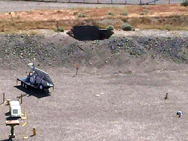 This image provided by the U.S. Department of Energy shows a 20-foot by 20-foot hole in the roof of a storage tunnel at the Hanford Nuclear Reservation near Richland, Wash., Tuesday, May 9, 2017. An emergency was declared Tuesday after the partial collapse of the tunnel that contains rail cars full of radioactive waste. (U.S. Department of Energy via AP)
