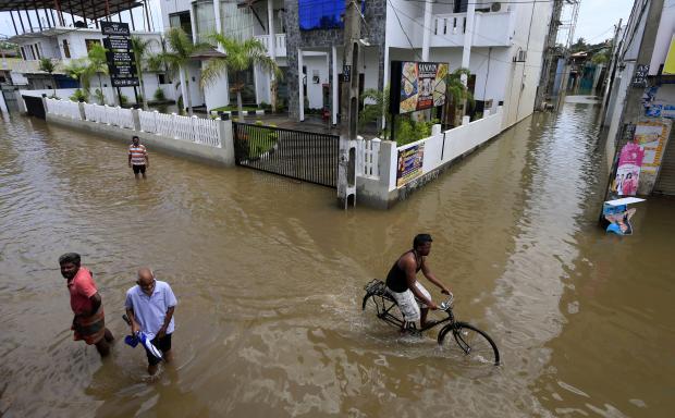 People wading through flooded street in Colombo in Sri Lanka - 28 May 2017
