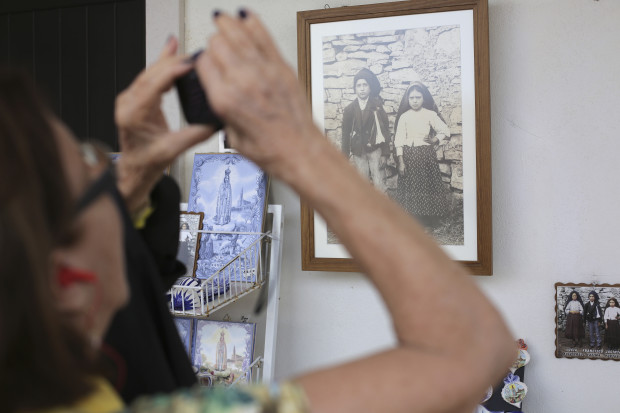 In this photo taken May 4 2017, a shop selling souvenirs displays a photo of Francisco and Jacinta Marto near the house where they lived in the village of Aljustrel, outside Fatima, Portugal. Pope Francis is visiting the Fatima shrine on May 12 and 13 to canonize Francisco and Jacinta Marto, two Portuguese shepherd children who say they saw visions of the Virgin Mary 100 years ago. (AP Photo/Armando Franca)