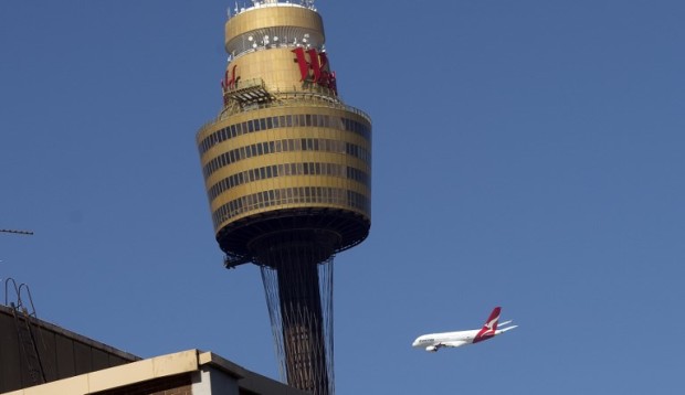 A Qantas A-380 Airbus flies low over Sydney's CBD on March 11, 2013, as a tribute to former Qantas CEO James Strong who died last week aged 68. A prominent Australian businessman, Strong was also the chairman of the organising committee for the 2015 cricket World Cup in Australia and New Zealand. AFP PHOTO / SAEED KHAN / AFP PHOTO / SAEED KHAN