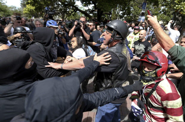 In this April 15, 2017 file photo, anti President Donald Trump protesters clash with Trump supporters during competing demonstrations at Martin Luther King Jr. Civic Center Park in Berkeley, Calif. Authorities say a former San Francisco Bay Area junior college professor has been arrested for allegedly beating three people during violent clashes between supporters and detractors of President Donald Trump last month. (Anda Chu /San Jose Mercury News via AP, File)