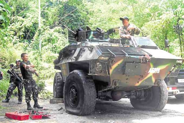 A military armored vehicle suffers a flat tire after it was hit by an explosive device while it was on its way to facilities of Lapanday attacked by communist rebels in Davao del Norte. —ARJOY M. CENIZA