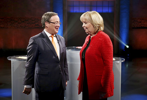 FILE - In this May 2, 2017 file photo Armin Laschet, left, top candidate of chancellor Angela Merkel's Christian Democratic Union, party  and North Rhine-Westphalia governor Hannelore Kraft  of the Social Democratic Party talk to each other before a TV debate in Cologne, Germany.  Germany’s most populous state is holding an election Sunday May 14, 2017  that serves as a prelude to a national vote four months away, and could give conservative Chancellor Angela Merkel new momentum in her quest for a fourth term. The election for the state legislature in North Rhine-Westphalia is an important test for Merkel’s center-left challenger, Martin Schulz, whose party’s poll ratings surged after he was nominated in January but have since sagged.   (Oliver Berg/dpa via AP,file)