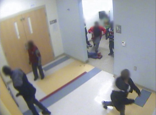 In this still image from a Jan. 24, 2017, surveillance video provided by Cincinnati Public Schools, the legs and feet of 8-year-old Gabriel Taye can be seen as he lies on the floor of a boys' bathroom after being knocked unconscious by another boy at Carson Elementary School. Two days later, Taye hanged himself with a necktie in the bedroom of his Cincinnati apartment. (Cincinnati Public Schools via AP)