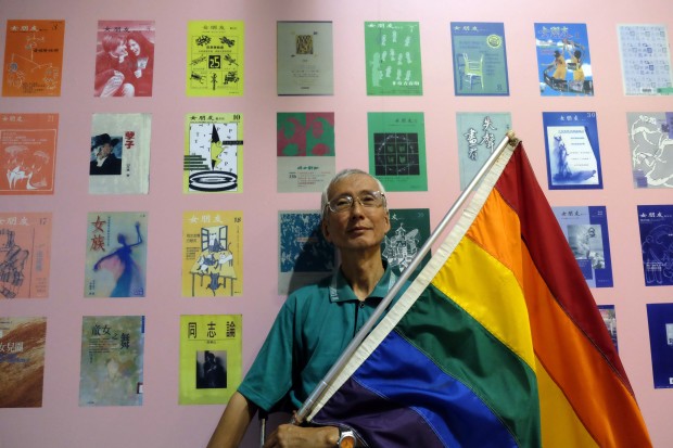 This picture taken on May 19, 2017 shows Taiwanese gay rights campaigner Chi Chia-wei, 59, posing for a photograph with a flag during an exhibition in Taipei. A court ruling in Taiwan this week could make the island the first place in Asia to legalise same-sex marriage in a decision that will give activists around the region renewed hope as they also seek equality. / AFP PHOTO / SAM YEH / TO GO WITH STORY "TAIWAN-HOMOSEXUALITY-MARRIAGE-COURT-RIGHTS ", BY MICHELLE YUN