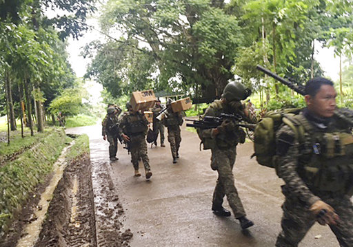 Philippine troops arrive at their barracks to reinforce fellow troops following the siege by Muslim militants Wednesday, May 24, 2017 in the outskirts of Marawi city in southern Philippines. Muslim extremists abducted a Catholic priest and more than a dozen churchgoers while laying siege to a southern Philippine city overnight, burning buildings, ambushing soldiers and hoisting flags of the Islamic State group, officials said Wednesday. President Rodrigo Duterte declared martial law in the southern third of the nation and warned he would enforce it harshly. (AP Photo)