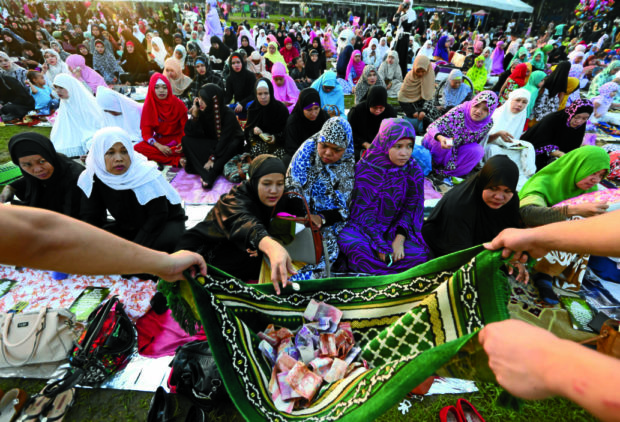 DONATIONS FOR MARAWI Muslim women, who gathered in Manila to celebrate Eid al-Fitr marking the end of the holy month of Ramadan, solicit cash donations on a prayer rug for Muslims and Christians caught in the war on terrorists in Marawi City. —MARIANNE BERMUDEZ