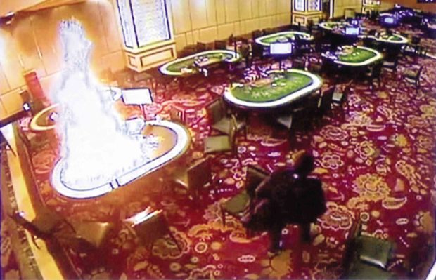 A security video grab shows the gunman torching one of the gambling tables upon entering the Pasay City casino. —AP