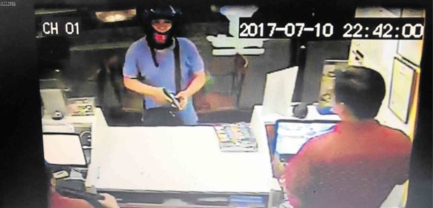 Photo grab from CCTV footage shows suspect pointing a gun at Angel’s Pizza crew. —QCPD PHOTO