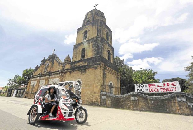 A tarpaulin protesting alleged summary killings in the war on drugs is displayed at Guimbal Church in Guimbal town, Iloilo province, which President Duterte has described as a key drug area. —NIÑO JESUS ORBETA