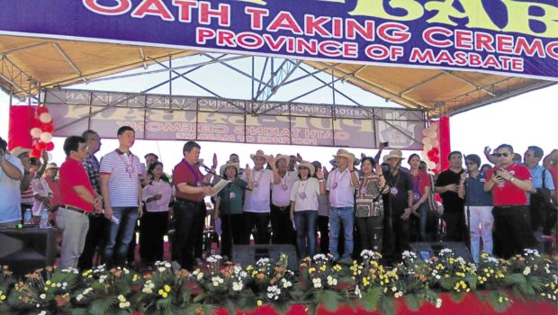 SHOW OF FORCE Senate President Aquilino Pimentel III (fifth from left) administers the oath of office to new members of the administration party PDP-Laban in Masbate province.