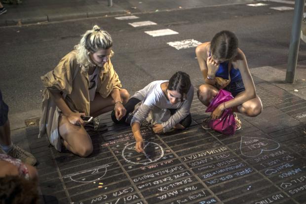 Girl drawing peace symbol on street in Barcelona - 18 Aug 2017