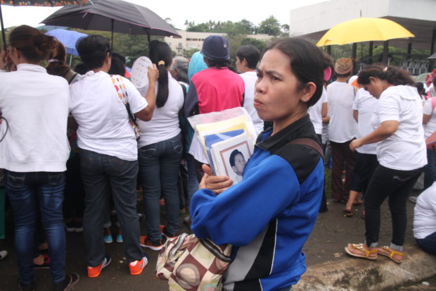 A woman holds a pamphlet detailing the achievements of the late former president Ferdinand Marcos at a gathering inside the University of the Philippines Los Banos campus in Laguna province organized by the group One Social Family where registrants are entitled to receive money from the Marcoses. PHOTO BY KIMMY BARAOIDAN/INQUIRER SOUTHERN LUZON