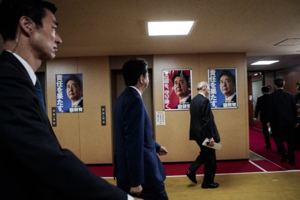 Japan's Prime Minister and ruling Liberal Democratic Party leader Shinzo Abe (2nd L) arrives at the party headquarters in Tokyo on October 22, 2017. / AFP PHOTO / Behrouz MEHRI