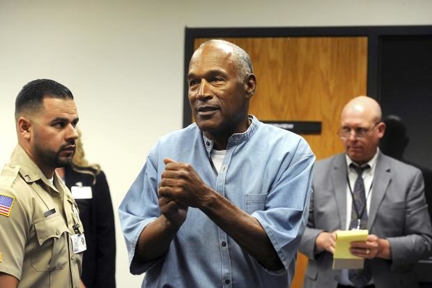 In this photo, taken July 20, 2017, former NFL football star O.J. Simpson reacts after learning he was granted parole during a hearing at the Lovelock Correctional Center in Lovelock, Nev. Simpson was granted parole after more than eight years in prison for a Las Vegas hotel heist. A Nevada prison official said early Sunday, Oct. 1, 2017, O.J. Simpson, the former football legend and Hollywood star, has been released from a Nevada prison in Lovelock after serving nine years for armed robbery. (Pool photo by JASON BEAN / The Reno Gazette-Journal via AP)