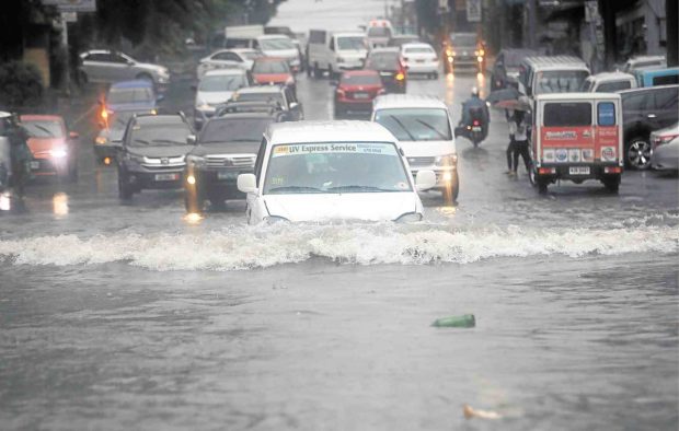 Vehicles cross a flooded portion of Scout Tobias Street  in Quezon City following  heavy rains brought by a tropical depression.  —GRIG C. MONTEGRANDE