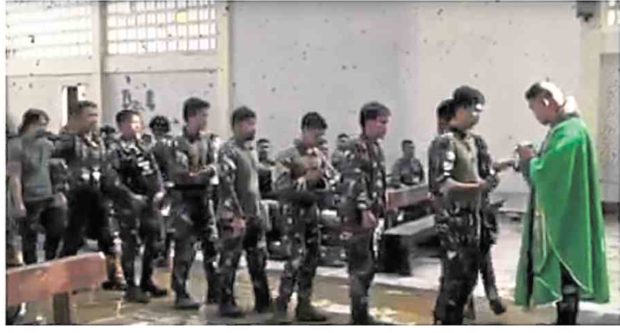 An Army chaplain is shown in this video grab blessing soldiers who heard Mass at the first religious service in St. Mary’s Cathedral since war started in Marawi City on May 23. —PHOTO COURTESY OF JOINT TASK FORCE RANAO