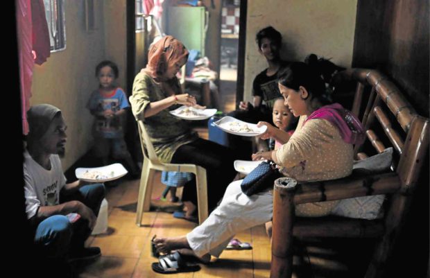 MEAL TIMEFamily members share a meal as they return to check on their home in war-torn Marawi City in the last week of October after the government declared the end of the five-month war against terrorists. —JEOFFREY MAITEM