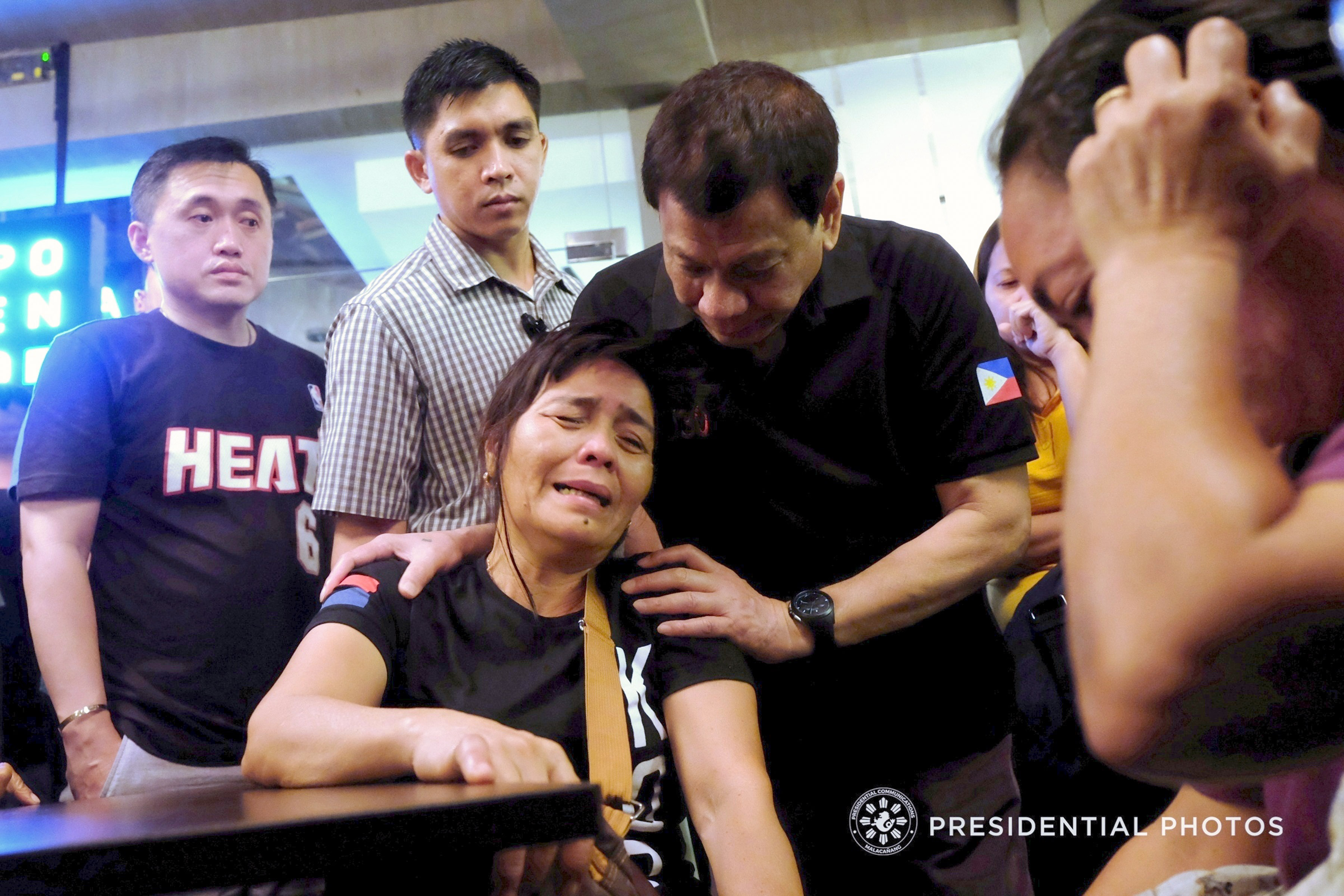 President Rodrigo Roa Duterte consoles the relatives of one of the victims who were trapped inside the NCCC Mall Davao upon hearing the news that their loved ones may have zero chance of survival as the fire inside the mall continues to rage as of dawn of December 24, 2017. Joining the President is Special Assistant to the President Christopher Lawrence Go. KIWI BULACLAC/PRESIDENTIAL PHOTO