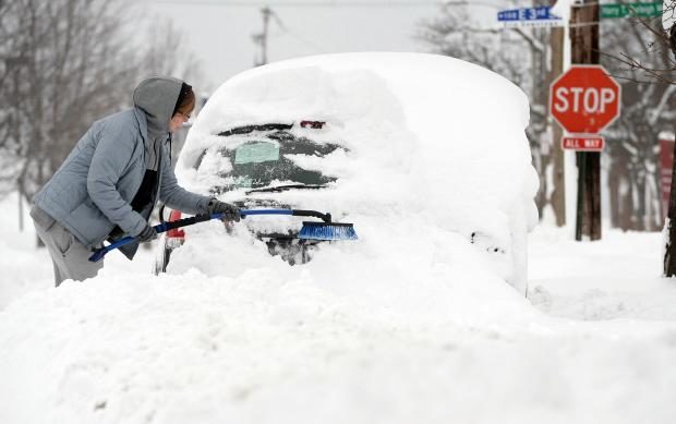 Woman scraping snow off car - Pennsylvania - 27 Dec 2017