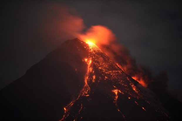 This photo taken on January 28, 2018 shows Mayon volcano spewing lava ash from its crater, as seen in Daraga town, south of Manila in Albay province. Authorities have imposed a no-go zone around the 2,460-metre (8,070-foot) mountain as they warned of a hazardous eruption within days, leaving more than 77,000 people stuck in crowded shelters, likely for months. / AFP PHOTO / Ted ALJIBE
