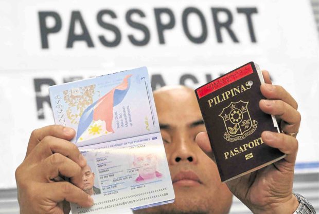 Man holding up two Philippine passports