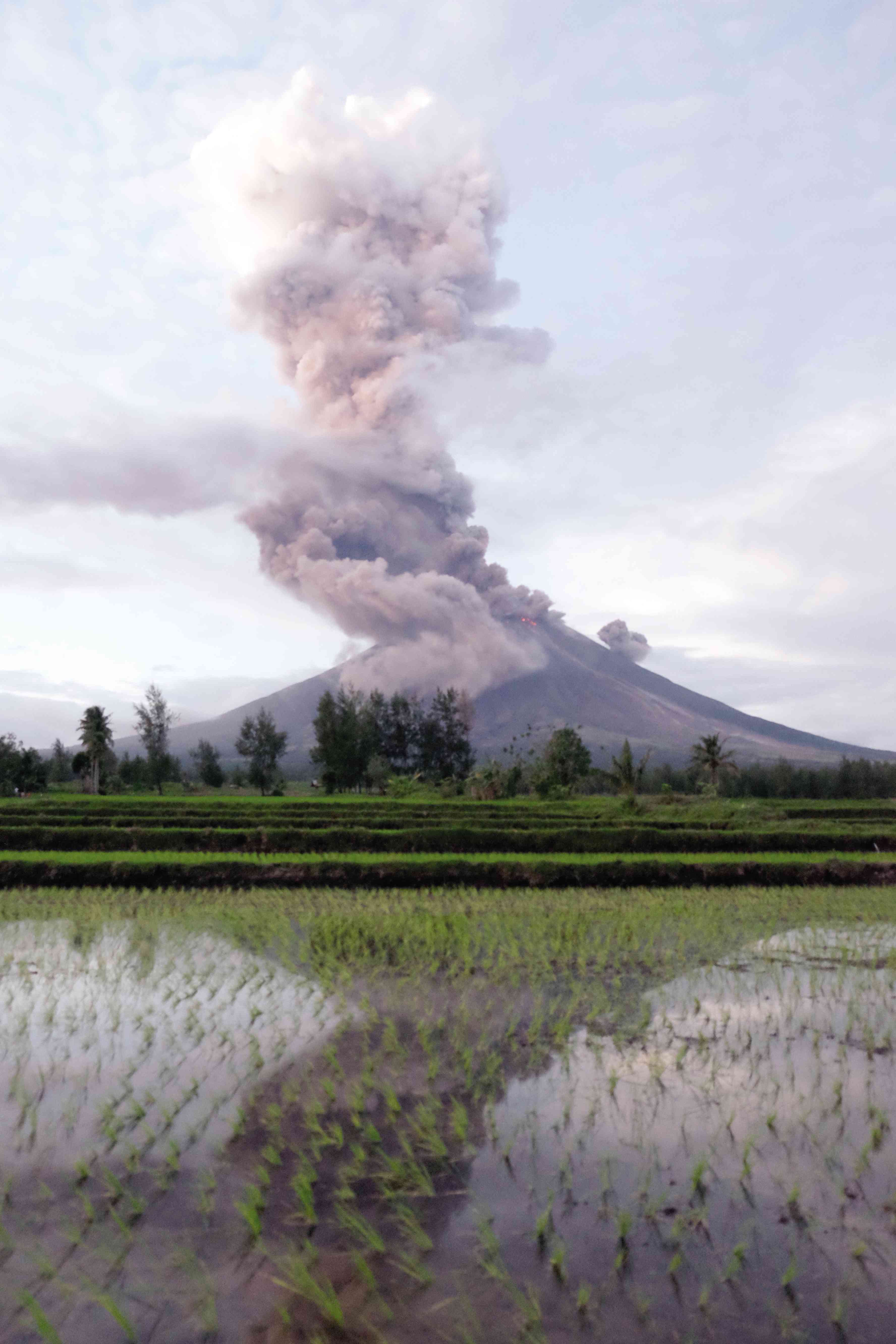 An image of Mayon spewing ash and pyroclastic materials is reflected on a farm in the village of Busay in Daraga town, Albay province. The country’s most active volcano continued to show signs of unrest and residents around danger zones had been told to flee. Authorities had raised Alert Level 4 in areas around the volcano, prohibiting entry into a 7-8 kilometer danger zone. —NIÑO JESUS ORBETA