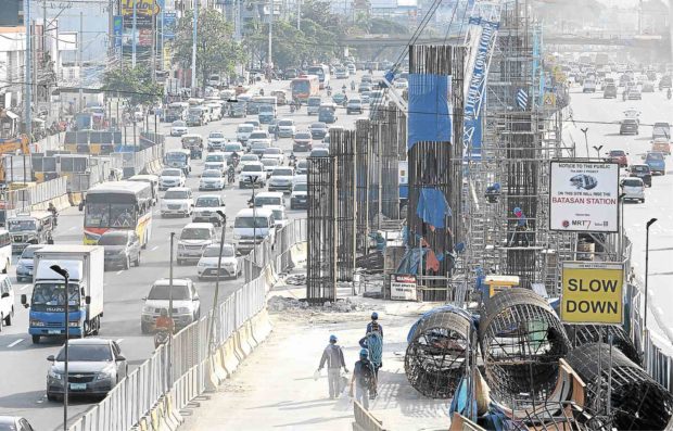 Motorists pass by the Batasan Station construction site of the MRT 7 along Commonwealth in Quezon City. (PHILIPPINE DAILY INQUIRER FILE PHOTO/GRIG C. MONTEGRANDE)