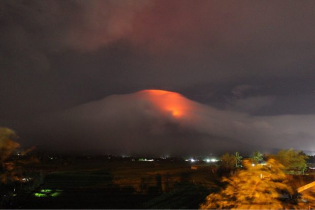 CRATER GLOW. An orange and yellow glow is seen at the crater of Mt. Mayon on Sunday evening, indicating that magma is near the surface, according to Phivolcs. Alert level 3 was raised over the volcano. Photo by Earl Epson Lim Recamunda, Contributor