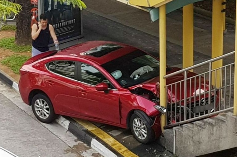 The red Mazda appeared to be heavily damaged after hitting the railing at the base of the bridge's staircase in Jurong East Central on Jan 26, 2018. PHOTO: FACEBOOK/JEFF JEFF