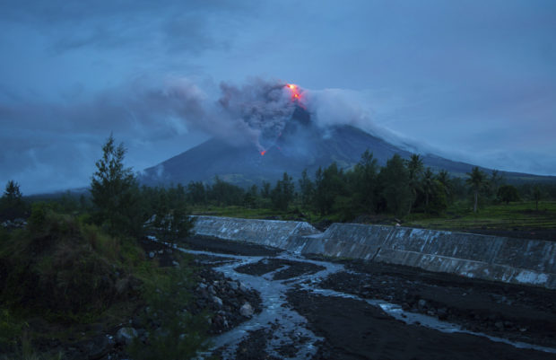 Lava cascades down the slopes of the Mayon volcano as seen from Busay Village in Legazpi city, Albay province, 340 kilometers (210 miles) southeast of Manila, Philippines, Tuesday, Jan. 16, 2018. More than 9,000 people have evacuated the area around the Philippines' most active volcano as lava flowed down its crater Monday in a gentle eruption that scientists warned could turn explosive. (AP Photo/Dan Amaranto)